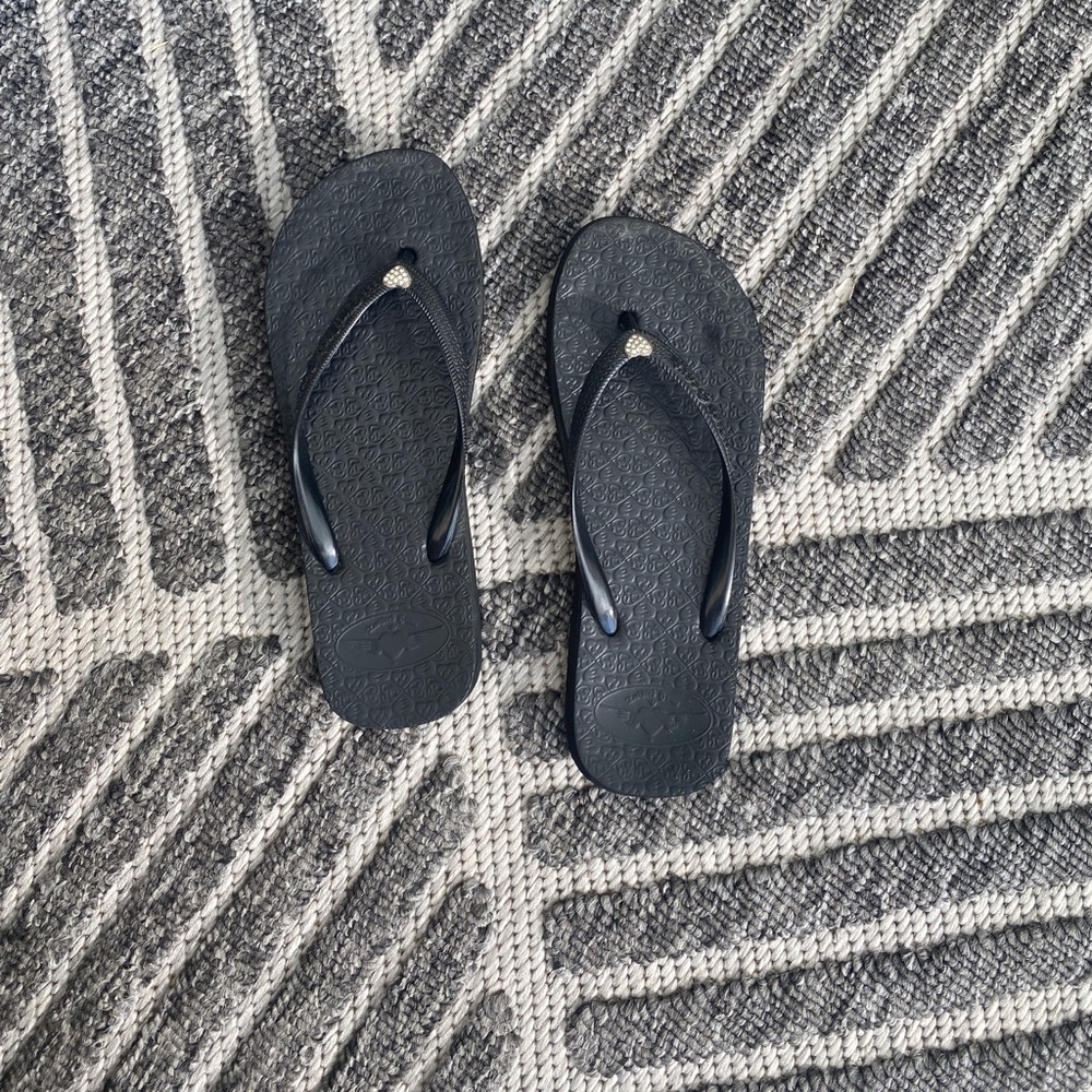 black flip flops with heart detail